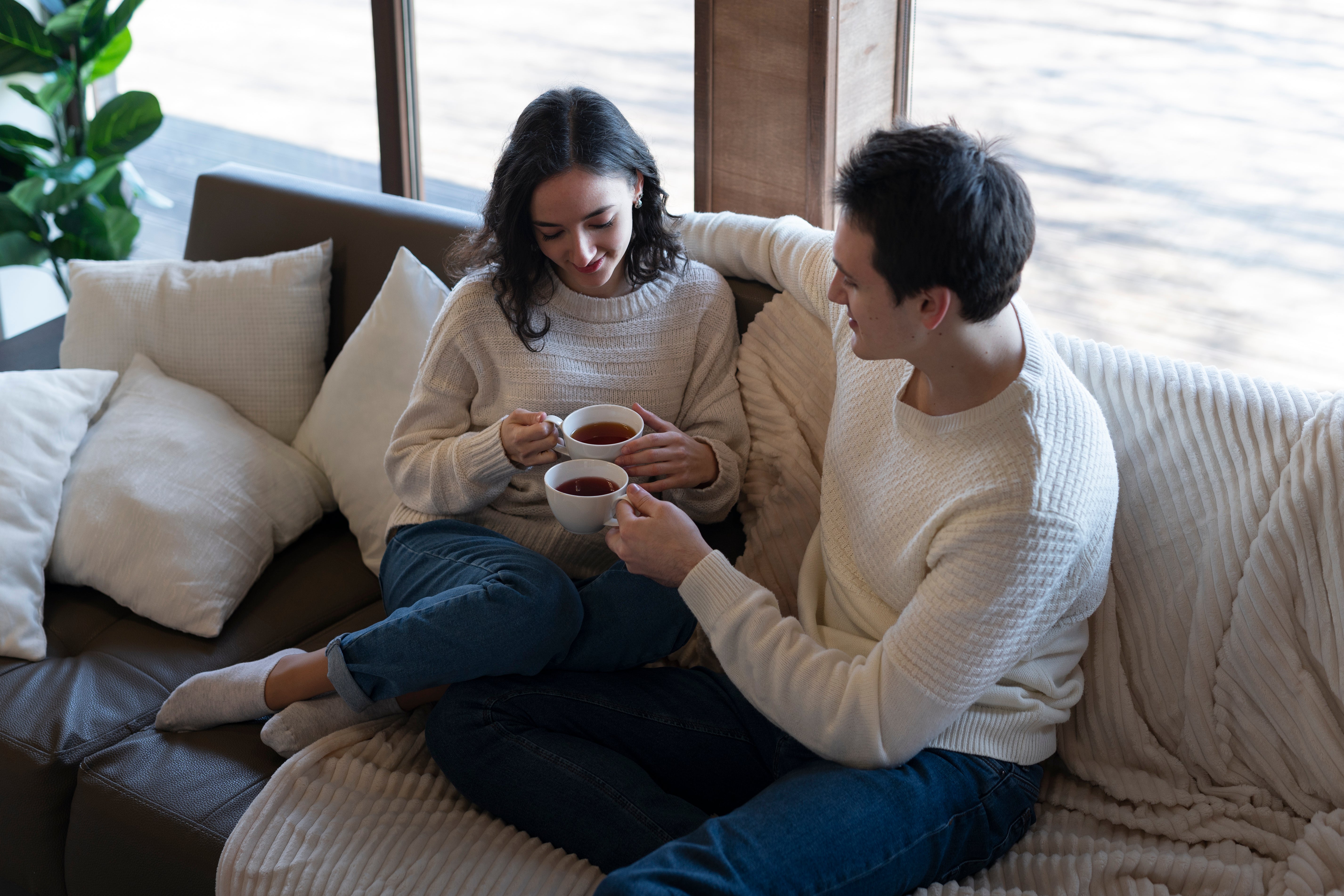 Couple sharing a cup of coffee on the sofa