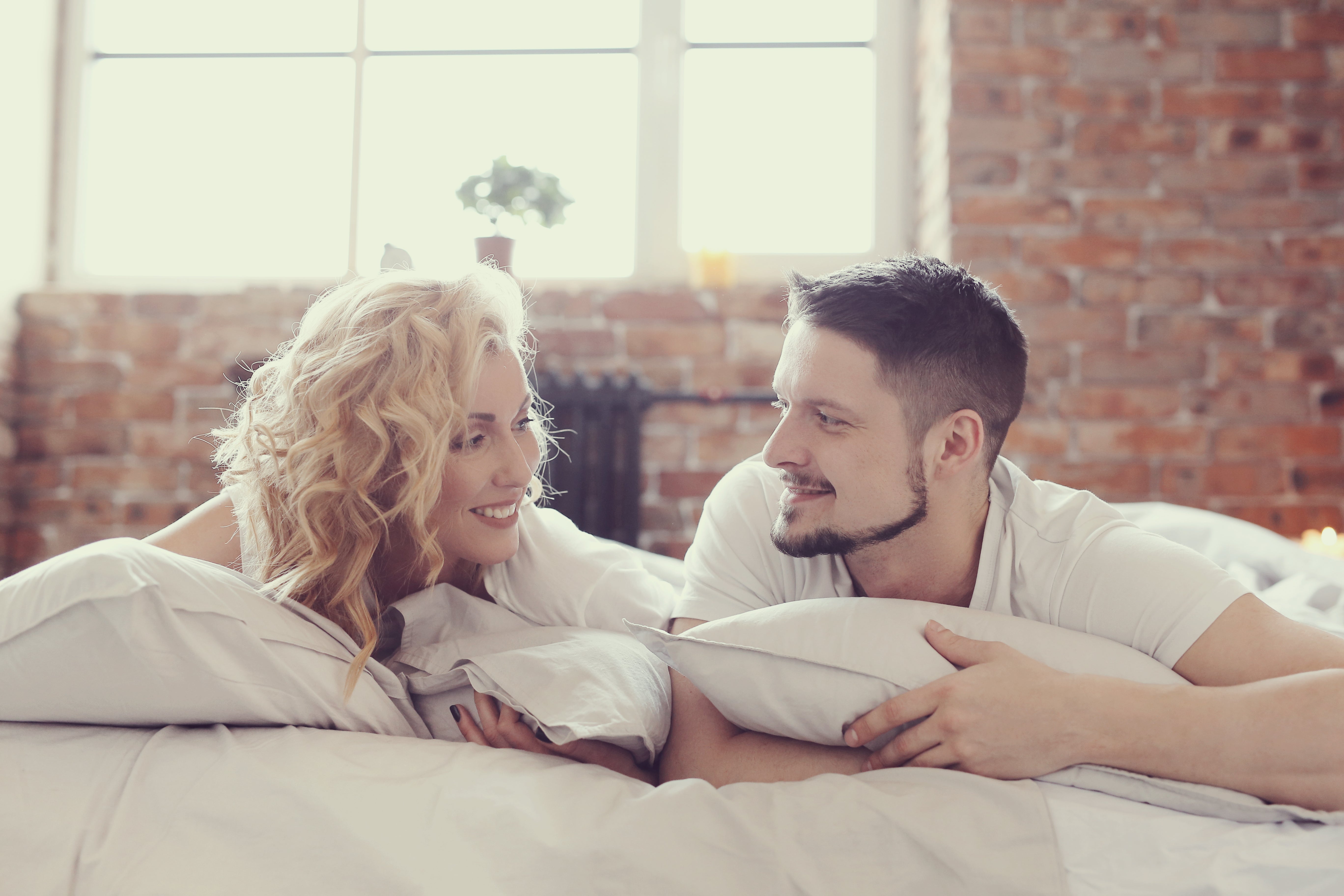 A couple in bed gazing into each other's eyes