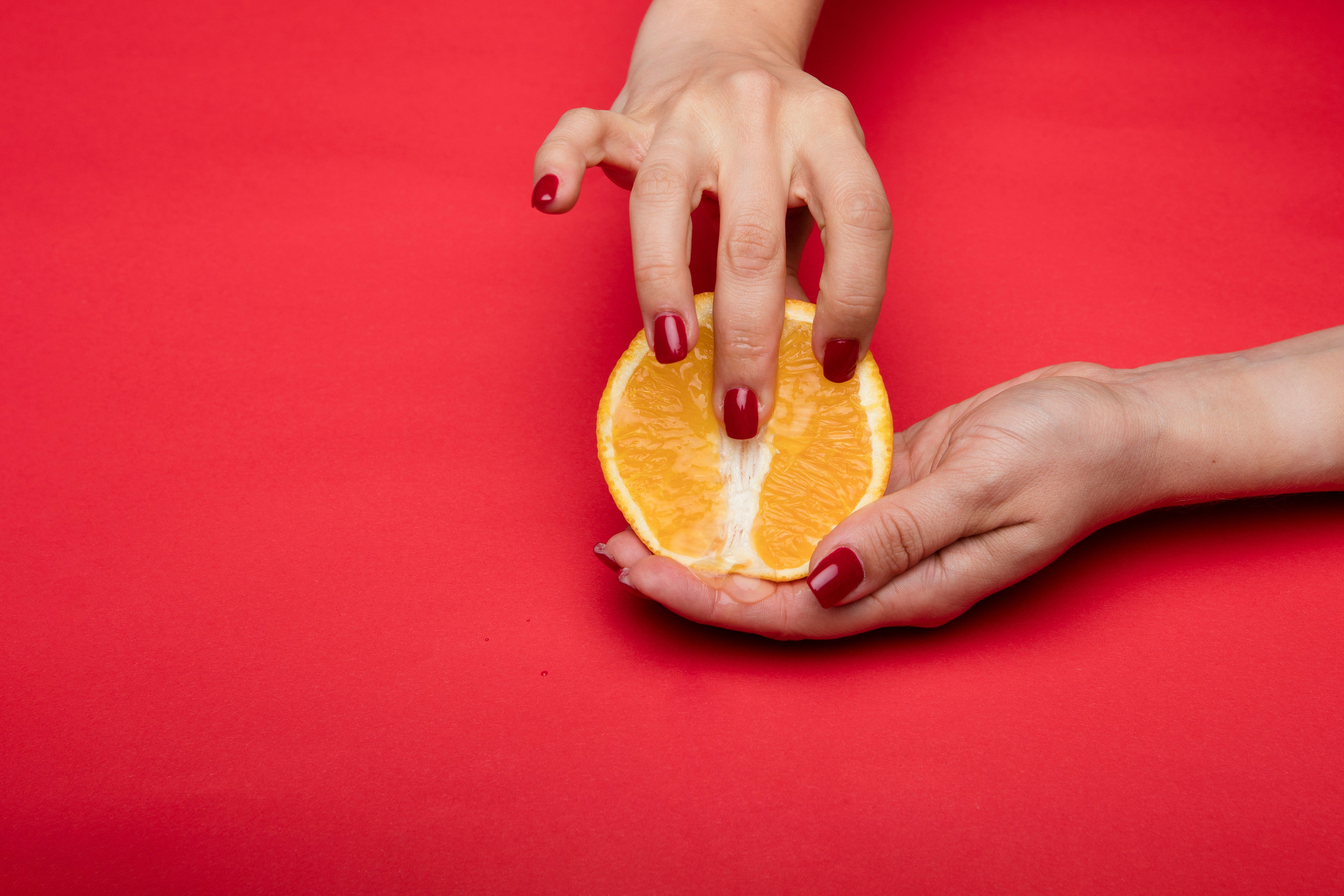 A woman fingering an orange